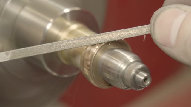 Jeweler, goldsmith in a professional jewelry workshop files down a gold ring , close up
