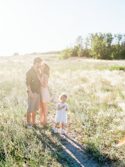 Happiness and harmony in family life. Happy family concept. Young mother and father and their daughter in the park. Happy family resting together on the green grass. Family having fun outdoor