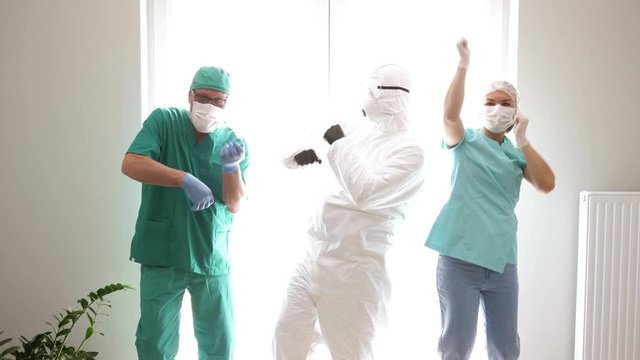 Team of doctors in protective clothing is dancing during a break in the hospital corridor. covid-19.