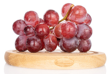 Lot of whole fresh red globe grape on wooden plate isolated on white