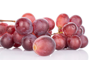 Lot of whole fresh red globe grape one berry in front isolated on white