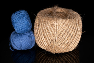Group of three whole thread spools isolated on black glass