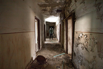 Dramatic portrait of a man wearing a gas mask in a ruined building.