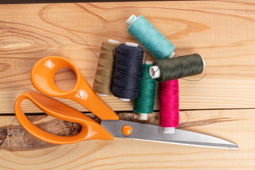 Scissors with thread spools on wood