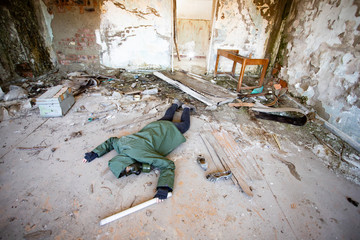 Dramatic portrait of a woman wearing a gas mask in a ruined building.
