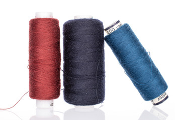 Group of three whole thread spools isolated on white