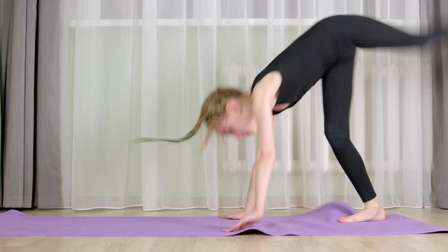 Flexible girl training acrobatic exercise in home. Acrobat girl bending to gymnastic bridge. Fit young woman exercising gym on home training