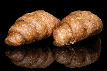 Group of two whole baked wholegrain croissant isolated on black glass