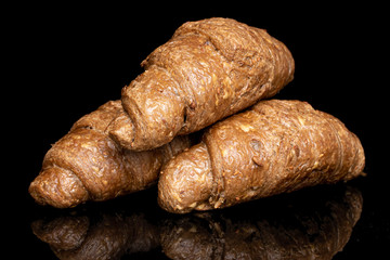 Group of three whole baked wholegrain croissant isolated on black glass