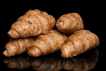 Group of five whole baked wholegrain croissant isolated on black glass