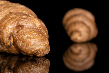 Group of two whole baked wholegrain croissant closeup isolated on black glass