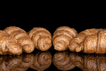 Lot of whole baked wholegrain croissant isolated on black glass