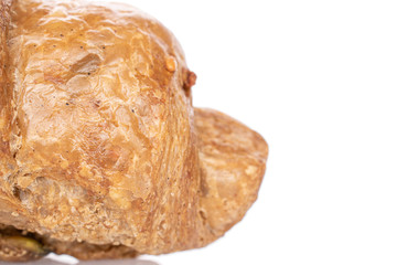 One whole baked wholegrain croissant closeup isolated on white