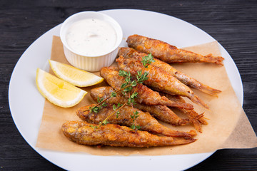 Fried drum on coal, served with lemon and sour cream