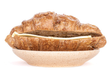 Group of two halves of baked wholegrain croissant with butter on plate isolated on white