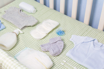 Set of clothing and body care supplies for newborns in baby crib. Collect the bag in the maternity hospital. Accessories for baby care. Preparation before your baby arrives.