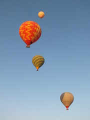 Fly-high. Colorful red, green and yellow Hot Air Balloons in row upwards in a clear blue sky