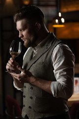 Professional sommelier man with a glass of white wine.