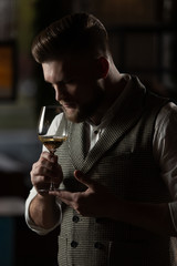 Professional sommelier man with a glass of white wine.