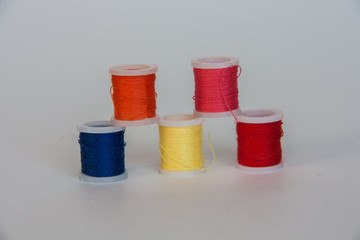 Color sewing threads on white background