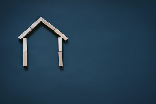 house of wooden blocks on a blue background, roof and walls the concept of real estate, house building, insurance, housing, family