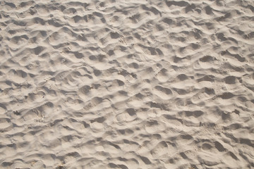 detail of sandy beach with marks of people walking at the beach