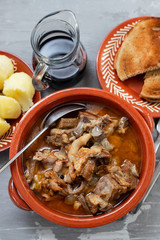 baked lamb with onion and pepper in the brown ceramic bowl