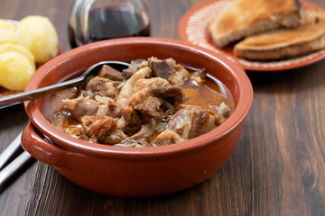 baked lamb with onion and pepper in the brown ceramic bowl