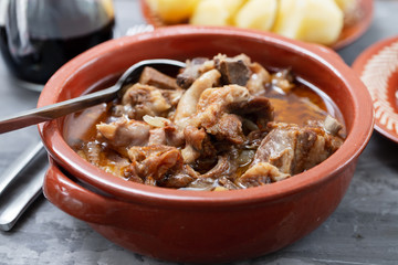 baked lamb with onion and pepper in the brown ceramic bowl