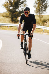 Bearded mature man in active wear and protective helmet doing sport activity on bike. Strong...