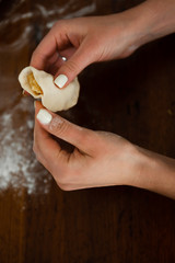 modeling dumplings over a wooden table,in the hands of the dough,cooking for european recipe,flour on the background of hands with dumpling