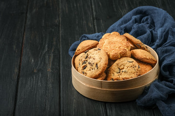 Mix of cookies in a wooden box on rustic background copy space.