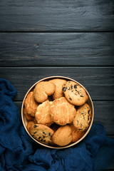 Mix of cookies in a wooden box on rustic background copy space.