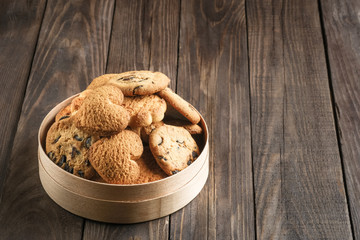 Mix of cookies in a wooden box on rustic background copy space.