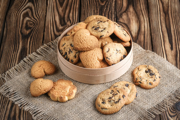 Mix of cookies in a wooden box on rustic background copy space.