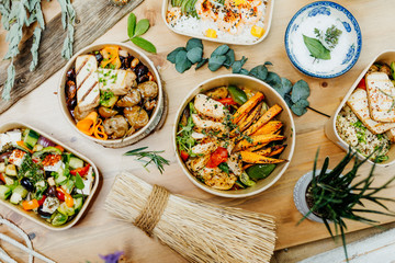 Various healthy and vitamin-rich dishes and food in an ecobox delivered by a delivery service, ordered online, decorated with bundles of straw, mussels and cacti, in a Mediterranean style