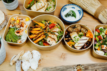 Various healthy and vitamin-rich dishes and food in an ecobox delivered by a delivery service, ordered online, decorated with bundles of straw, mussels and cacti, in a Mediterranean style