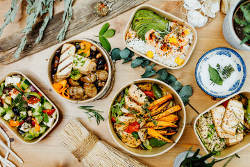 Various healthy and vitamin-rich dishes and food in an ecobox delivered by a delivery service, ordered online, decorated with bundles of straw, mussels and cacti, in a Mediterranean style
