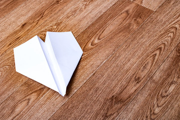 White paper plane on a wooden table