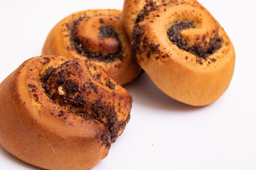 Three buns with poppy seeds on a white background