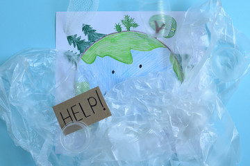 Children's drawing of planet Earth covered with plastic trash. Text HELP. The globe covered in plastic.Recycling concept. ecology, environmental pollution. earth day. Save our planet
