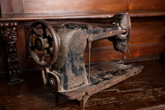 Antica  macchina da cucire arrugginita isolata su mobile di legno vintage