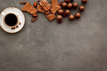Candy background with chocolate and coffee on grey desk top view frame. Pastry, confectionery concept. Copy space