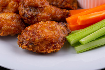 Fried legs and wings with breading, served with sauce and vegetables