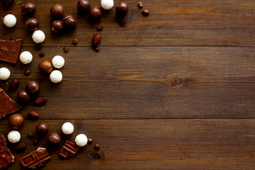 Sweets background with chocolate praline balls on wooden desk top-down frame copy space