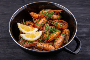 Fried shrimp on oil, served with greens and lemon