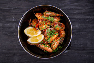 Fried shrimp on oil, served with greens and lemon