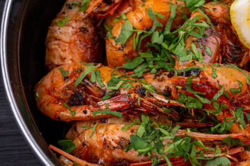 Fried shrimp on oil, served with greens and lemon