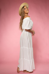 Beautiful blonde woman posing in white fashion dress