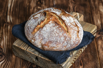 Delicious homemade bread on a napkin on rustic background.